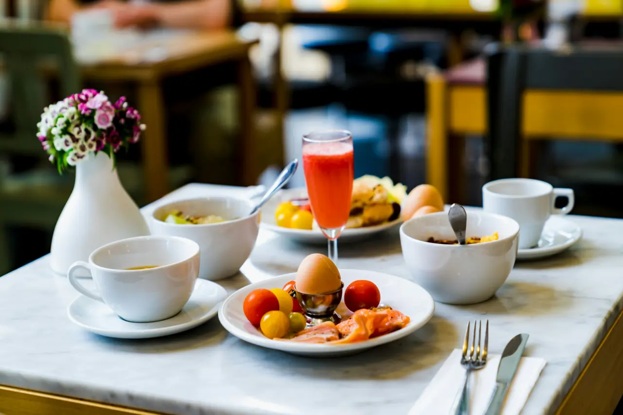 Gedeckter Frühstückstisch mit Eiern, Obst und Saft