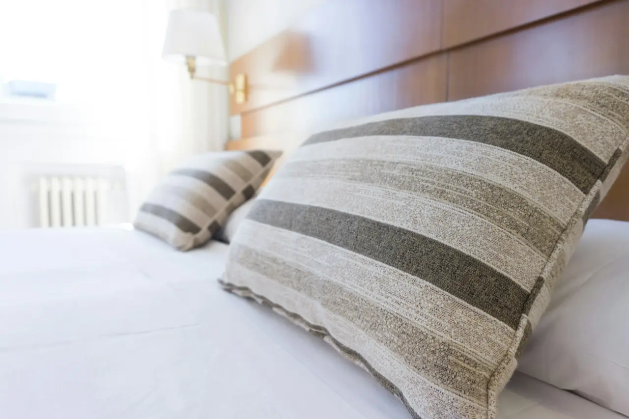 Gestreiftes Kissen auf einem frisch bezogenen Hotelbett