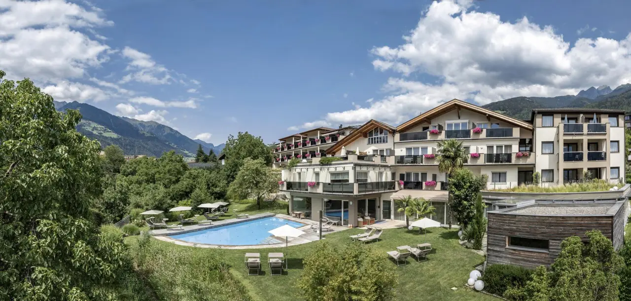 Baumgartner's Blumenhotel in Schenna – Außenansicht mit großem Pool und Liegewiese | Wellnesshotel Südtirol