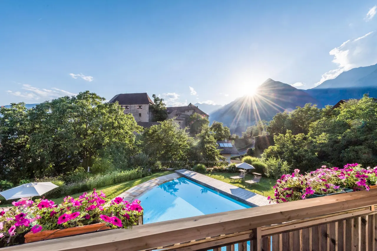 Baumgartner's Blumenhotel in Schenna – Außenpool mit Bergblick und Schloss | Wellnesshotel Südtirol