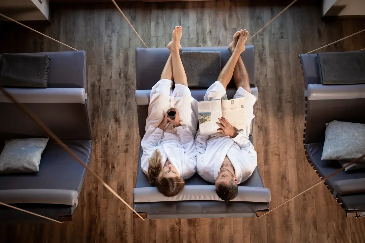 Wellness Natur Resort Gut Edermann in Teisendorf – Paar entspannt auf Hängesesseln im Wellnessbereich | Wellnesshotel Bayern