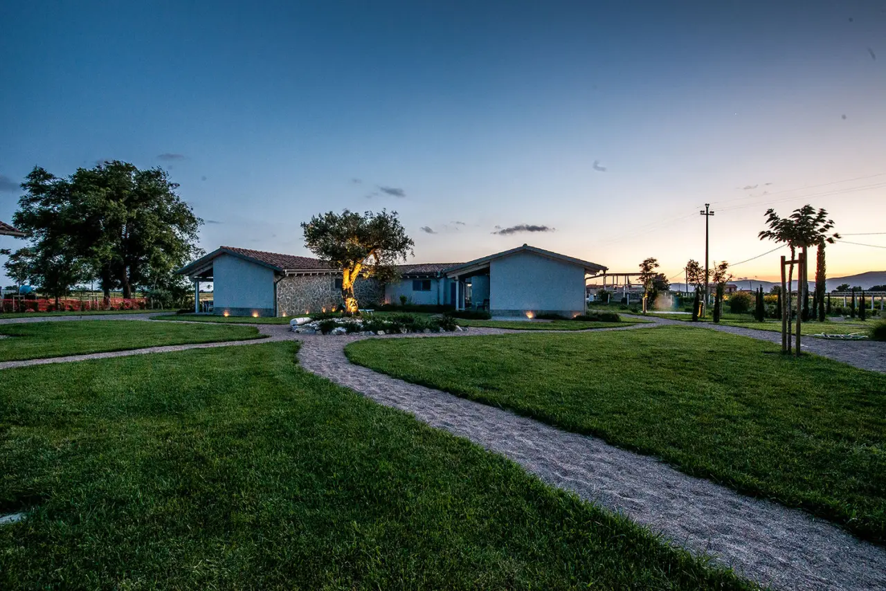 Refugium Toscana Country House in Grosseto – Beleuchtete Gebäude und Gartenwege bei Dämmerung | Wellnesshotel Toskana