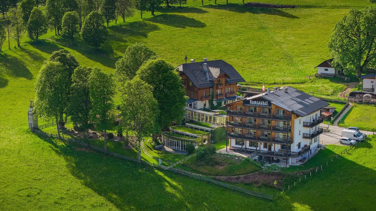 Hotel Ramsauhof in Ramsau am Dachstein – Hotelanlage umgeben von grünen Wiesen und Bäumen | Wellnesshotel Dachstein