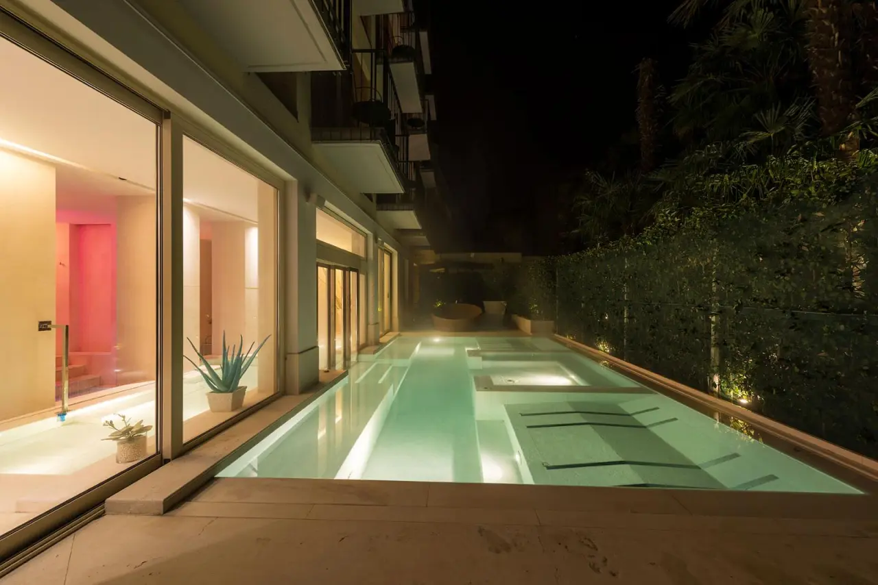 Hotel 4 Stagioni Sensus Spa in Bardolino – Beleuchteter Innen- und Außenpoolbereich bei Nacht | Wellnesshotel Gardasee
