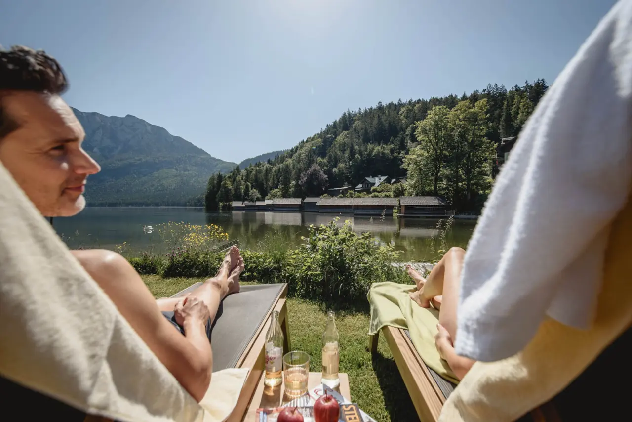 Romantik Hotel Seevilla in Altaussee – Gäste entspannen auf Liegestühlen am Altausseer See | Wellnesshotel Salzkammergut