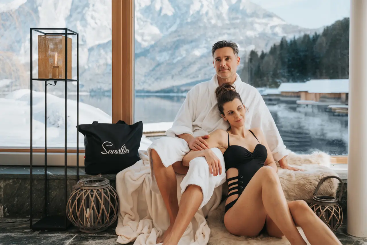 Romantik Hotel Seevilla in Altaussee – Paar entspannt im Bademantel mit Seeblick im Winter | Wellnesshotel Salzkammergut
