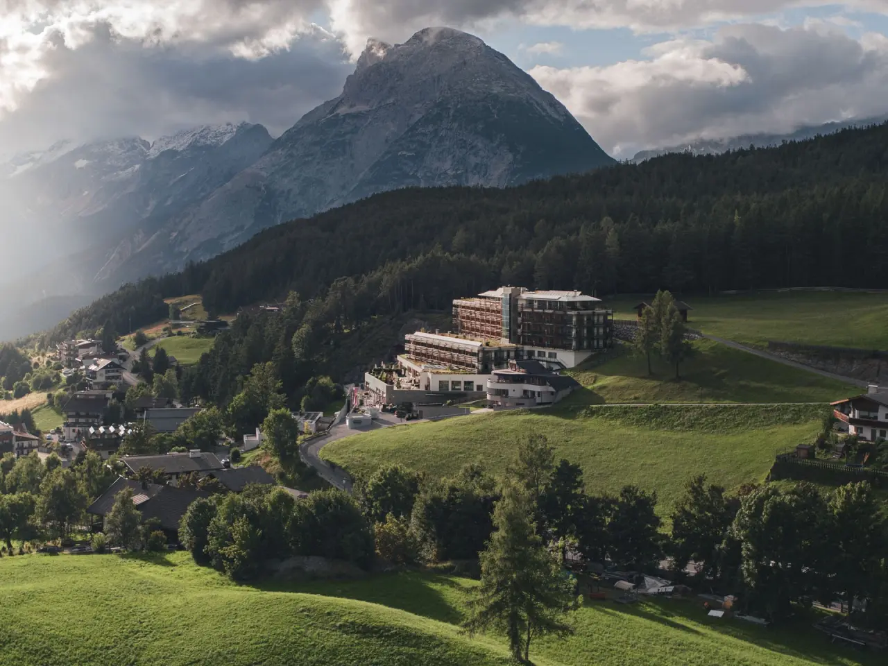 Hotel Nidum in Mösern – Panoramablick auf das Hotel und die umliegende Berglandschaft | Wellnesshotel Tirol