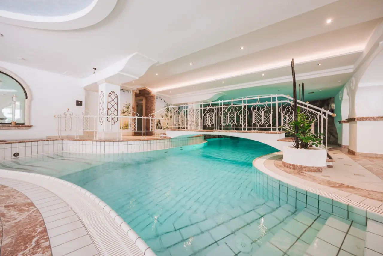 Hotel Gaspingerhof ****Superior in Gerlos – Innenpool mit eleganter Brücke | Wellnesshotel Zillertal