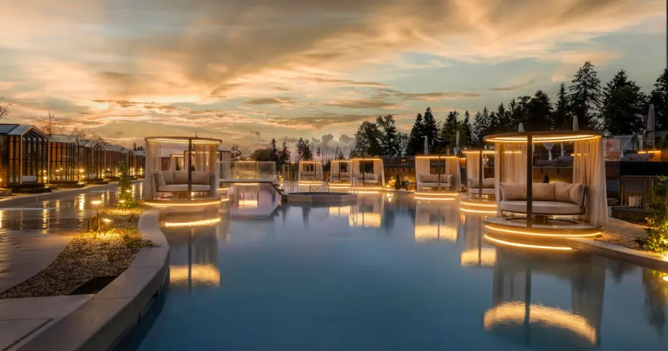 Das Stemp****S Wellnessresort in Büchlberg – Beleuchteter Außenpool mit luxuriösen Daybeds bei Sonnenuntergang | Wellnesshotel Bayerischer Wald