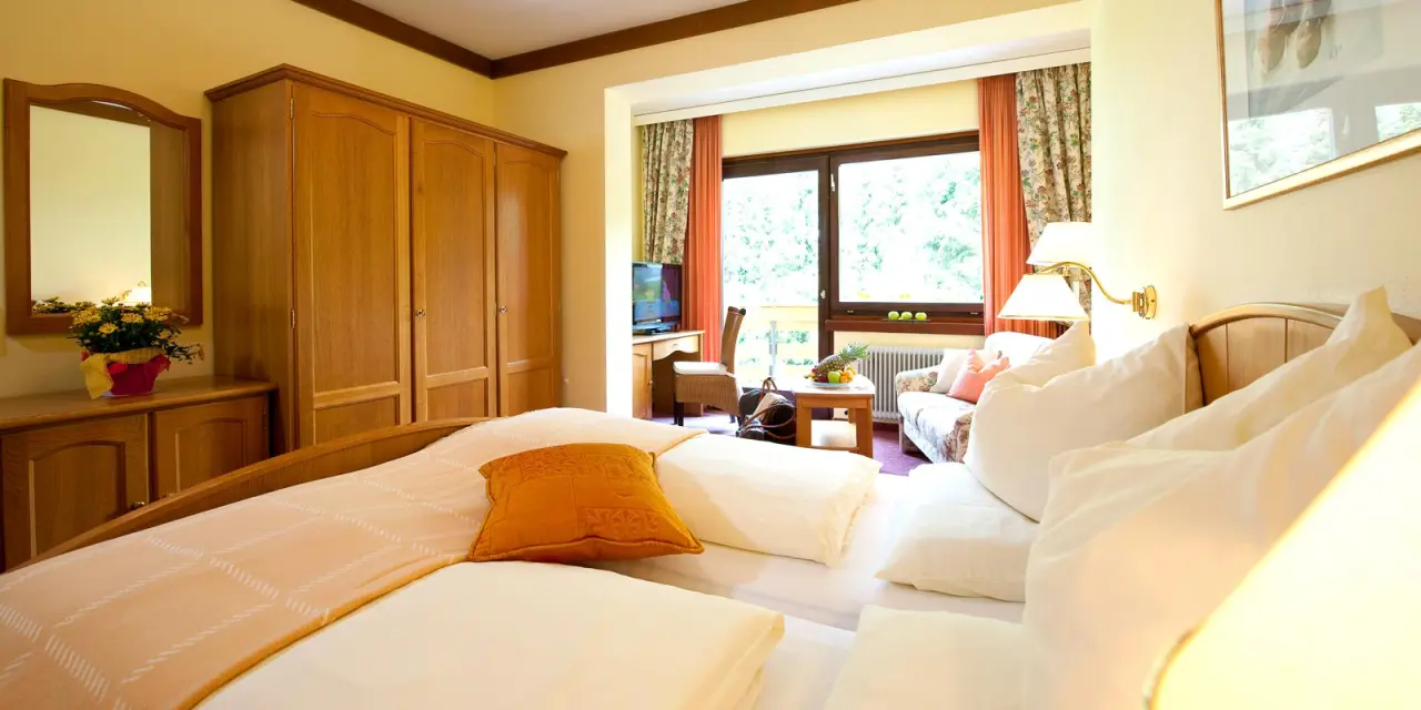 Hotel Felsenhof in Bad Kleinkirchheim – Gemütliches Hotelzimmer mit Doppelbett und Sitzbereich | Wellnesshotel Kärnten