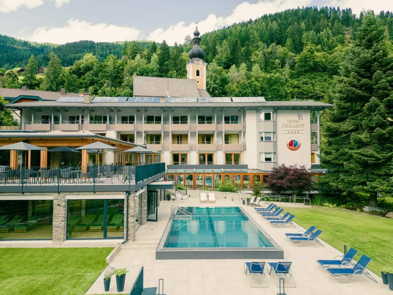 Evident Hotel Prägant in Bad Kleinkirchheim – Außenansicht mit Pool und Bergkulisse | Wellnesshotel Kärnten