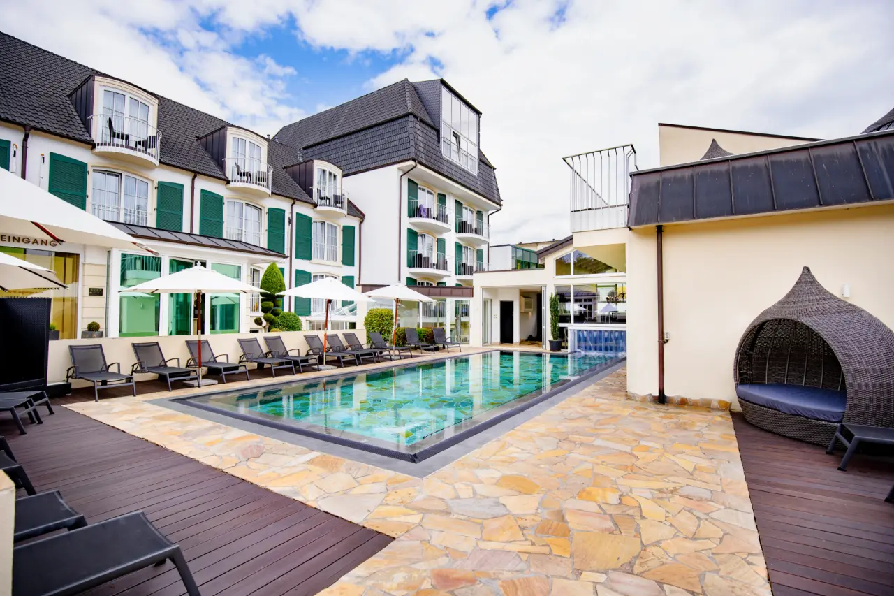 Lifestyle Resort Zum Kurfürsten in Bernkastel-Kues – Außenpool mit Liegen und Hotelgebäude | Wellnesshotel Mosel