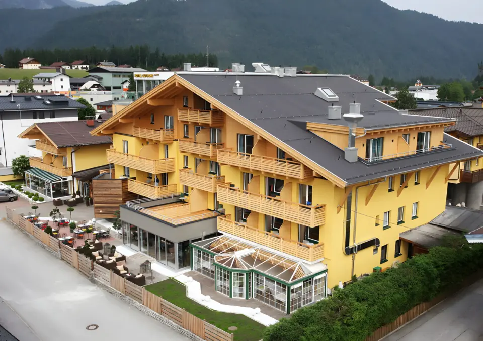 Hotel Gutjahr in Abtenau – Gesamtansicht des Hotels mit Außenterrasse und Wintergarten | Wellnesshotel Salzburger Land