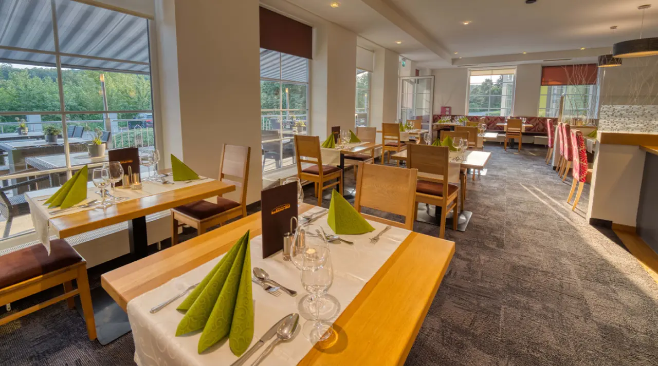 Hotel & SPA Reibener-Hof in Konzell – Helles Restaurant mit gedeckten Tischen und Terrassenzugang | Wellnesshotel Bayerischer Wald