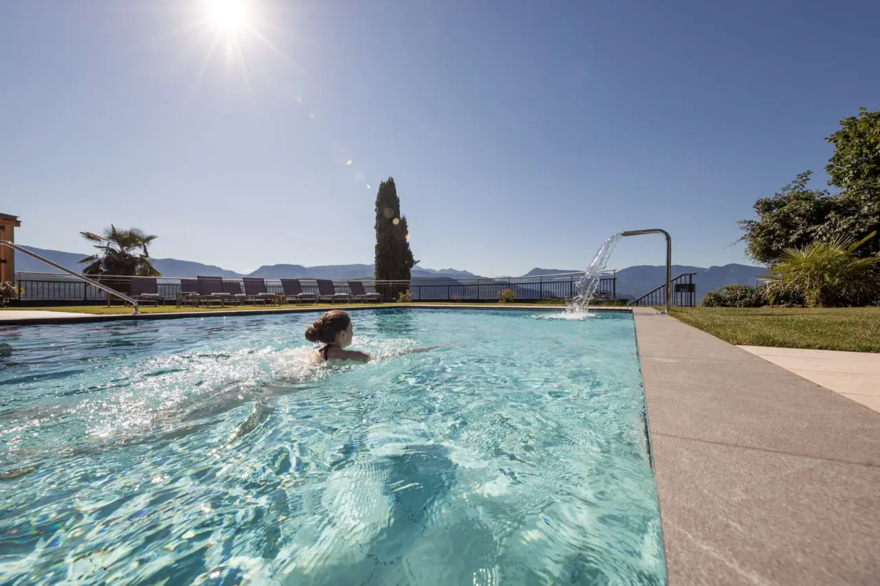 Hotel Torgglhof Kaltern in Kaltern – Außenpool mit Bergblick und Schwimmerin | Wellnesshotel an der Weinstraße