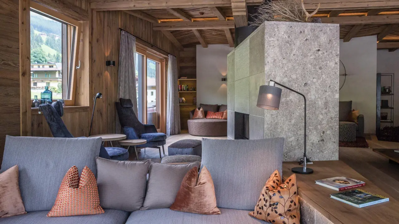 Hotel Alpin Spa Tuxerhof in Tux – Gemütlicher Wohnbereich einer Suite im alpinen Stil | Wellnesshotel Zillertal