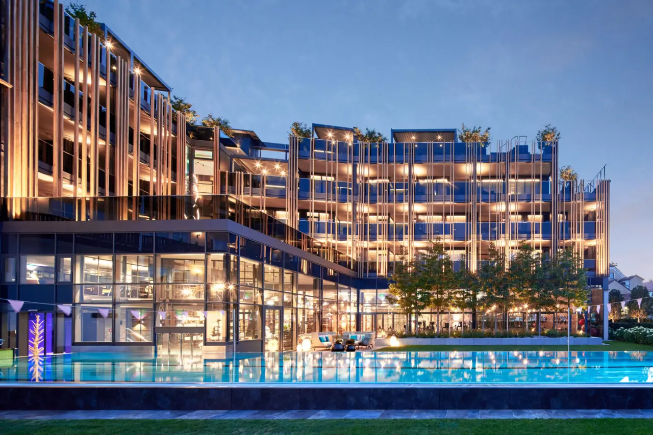 5-Sterne Wellness- & Sporthotel Jagdhof in Röhrnbach – Moderne Hotelarchitektur mit Außenpool am Abend | Wellnesshotel Bayerischer Wald