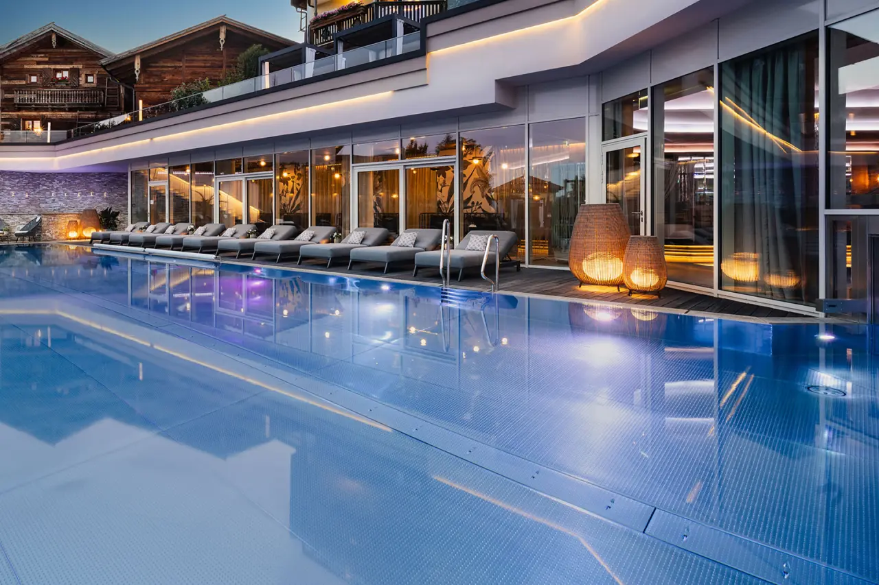5-Sterne Wellness- & Sporthotel Jagdhof in Röhrnbach – Außenpoolbereich am Abend mit Hotelansicht | Wellnesshotel Bayerischer Wald