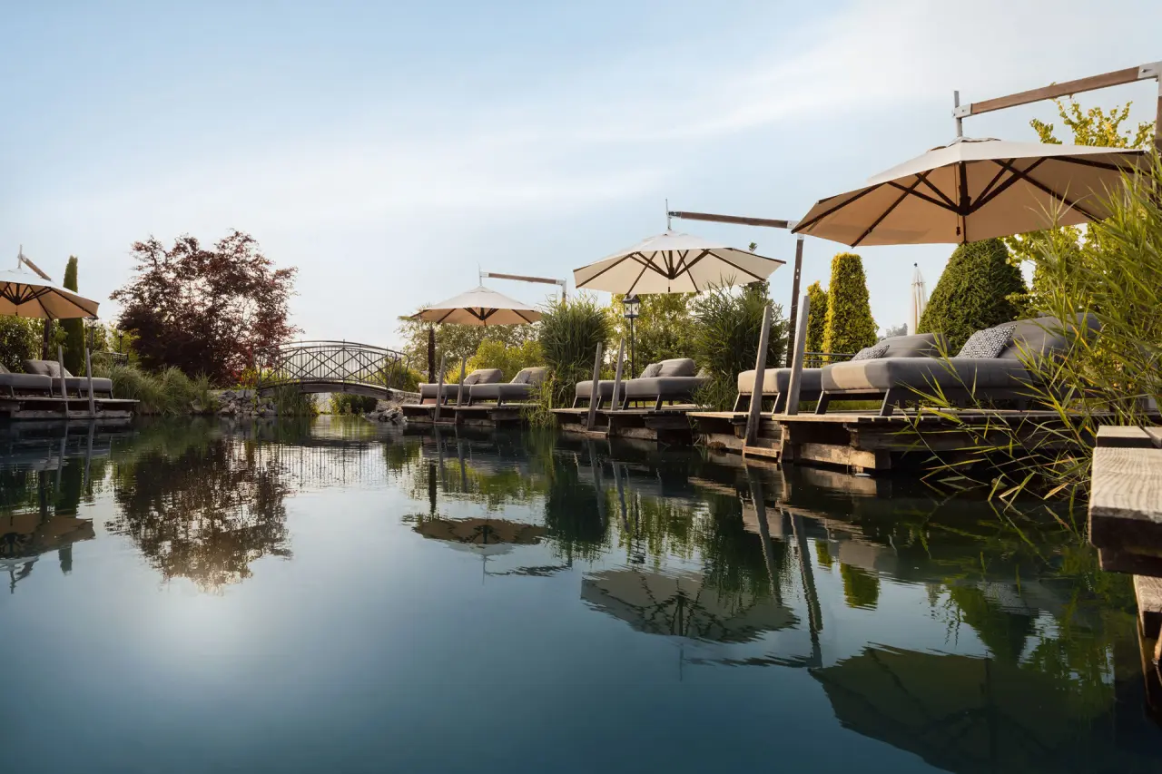 5-Sterne Wellness- & Sporthotel Jagdhof in Röhrnbach – Naturbadeteich mit Liegeinseln und Sonnenschirmen | Wellnesshotel Bayerischer Wald