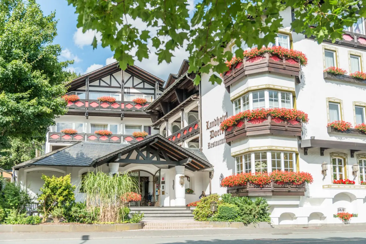 Landhotel Doerr in Bad Laasphe – Traditionelle Außenansicht mit Blumen und Restaurant | Wellnesshotel Sauerland