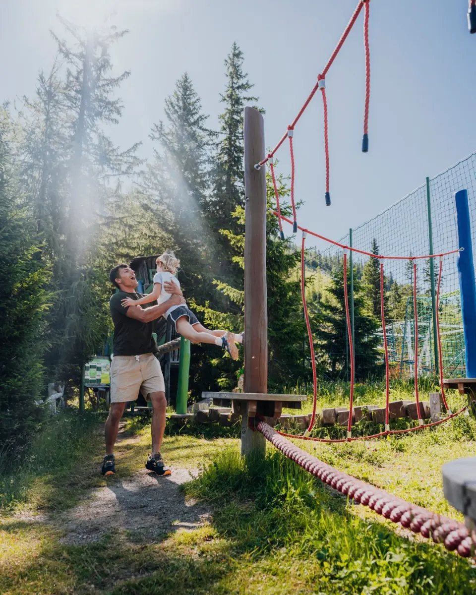 Das KATSCHBERG in Katschberghöhe – Vater und Kind auf einem Spielplatz im Freien | Wellnesshotel Katschberg