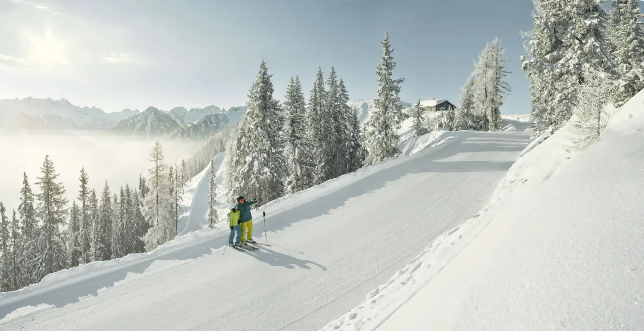 Sporthotel Royer Schladming in Schladming – Skifahrer auf sonniger Piste mit verschneiten Bäumen | Wellnesshotel Steiermark