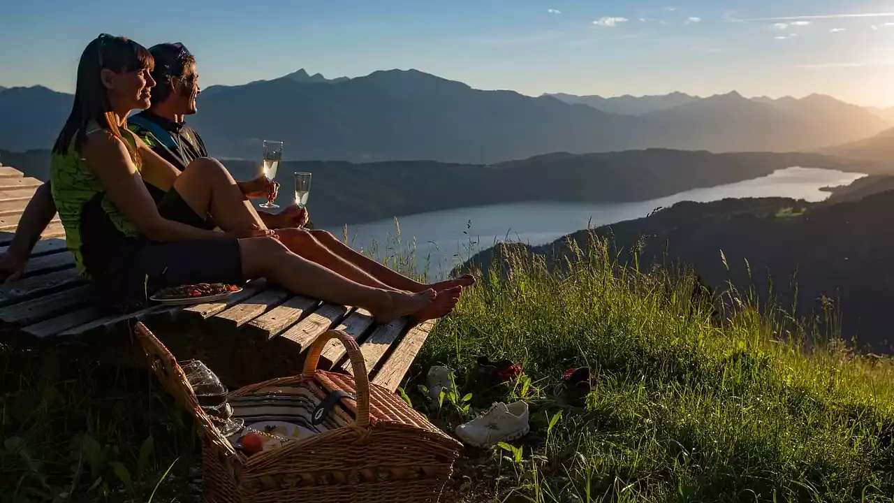 Hotel Moserhof in Seeboden – Paar beim Picknick mit Seeblick und Bergpanorama bei Sonnenuntergang | Wellnesshotel Kärnten