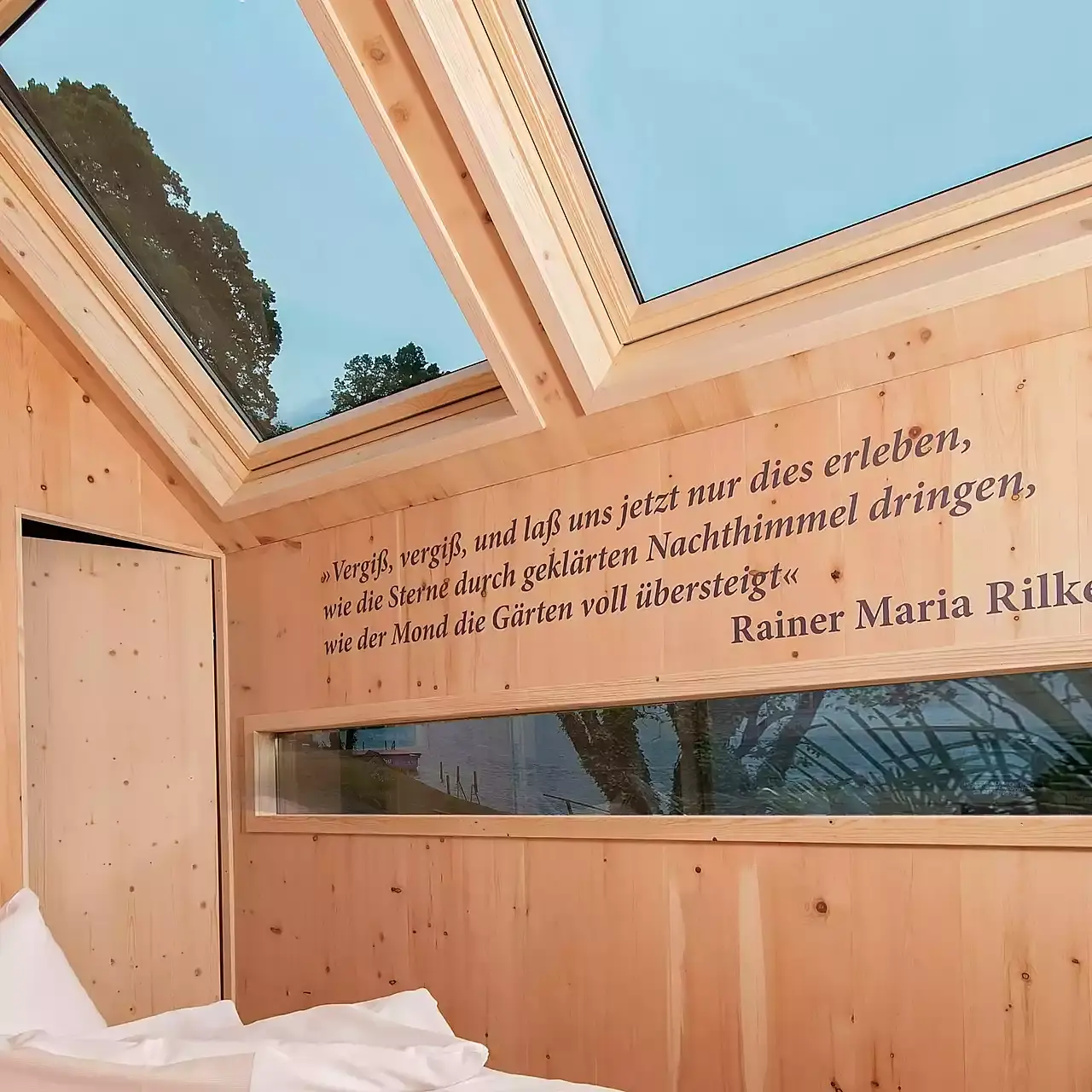Hotel Moserhof in Seeboden – Holzzimmer mit großem Dachfenster und inspirierendem Zitat | Wellnesshotel Kärnten