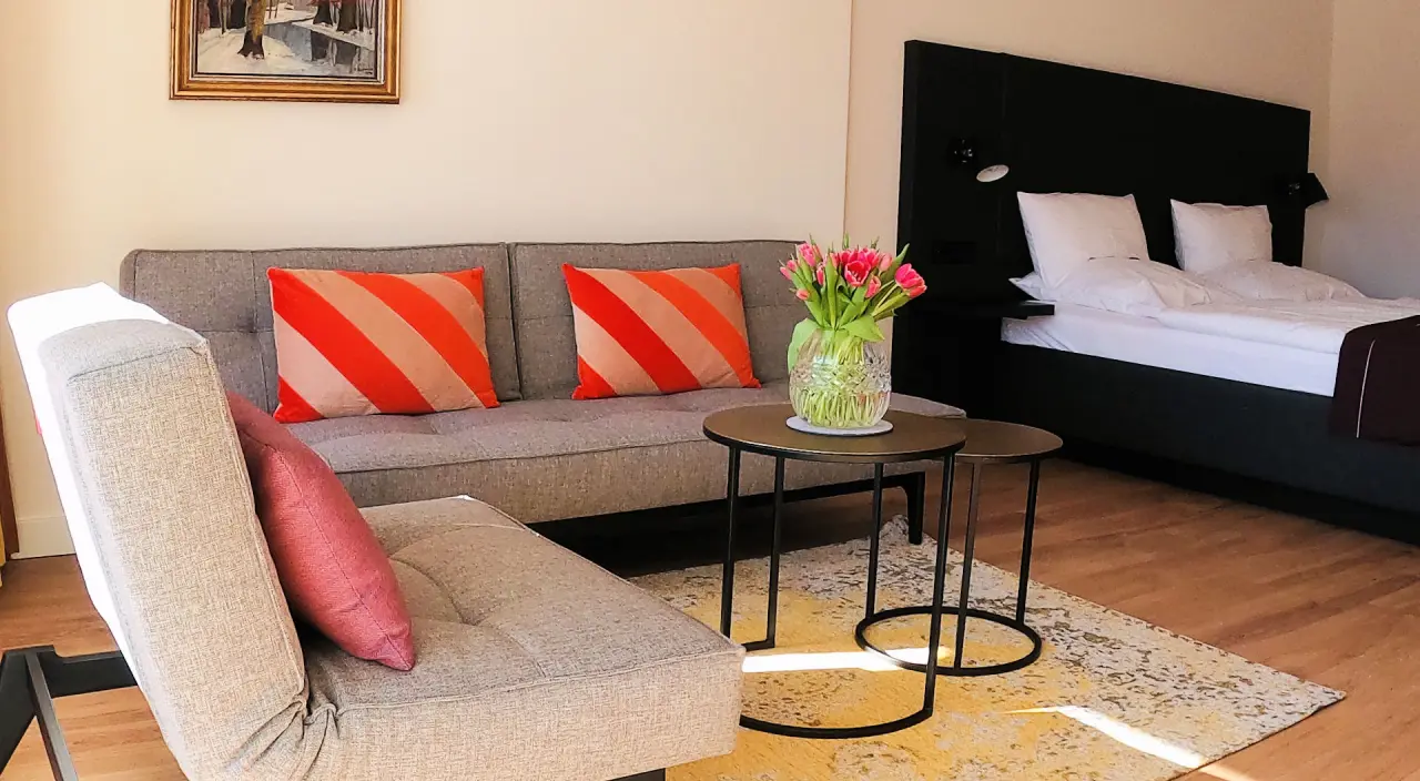Schwarzwaldhotel Oberwiesenhof in Seewald – Komfortables Doppelzimmer mit Sofa und Blumen | Wellnesshotel Schwarzwald