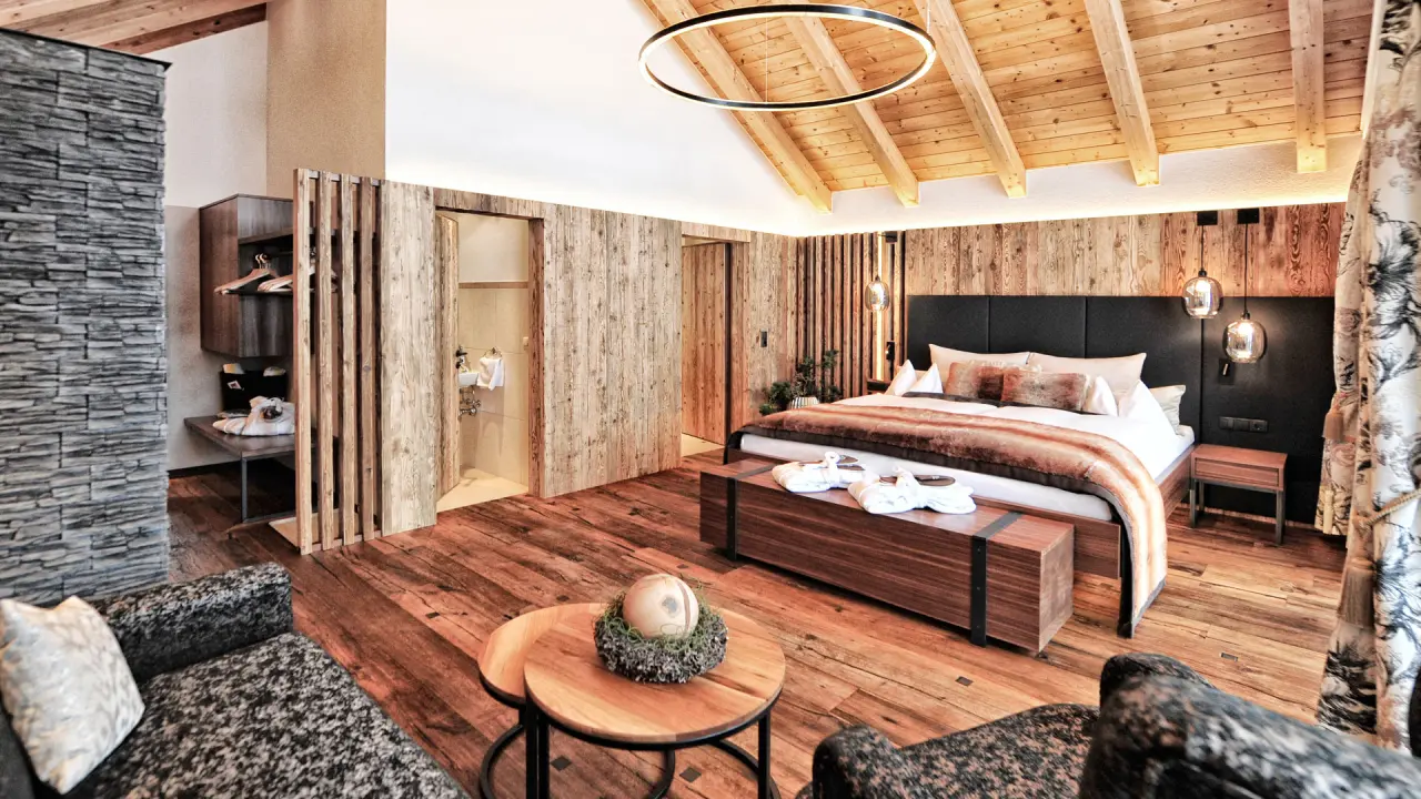 Hotel Salnerhof in Ischgl – Geräumiges Hotelzimmer mit Holzwänden und offenem Badbereich | Wellnesshotel Tirol