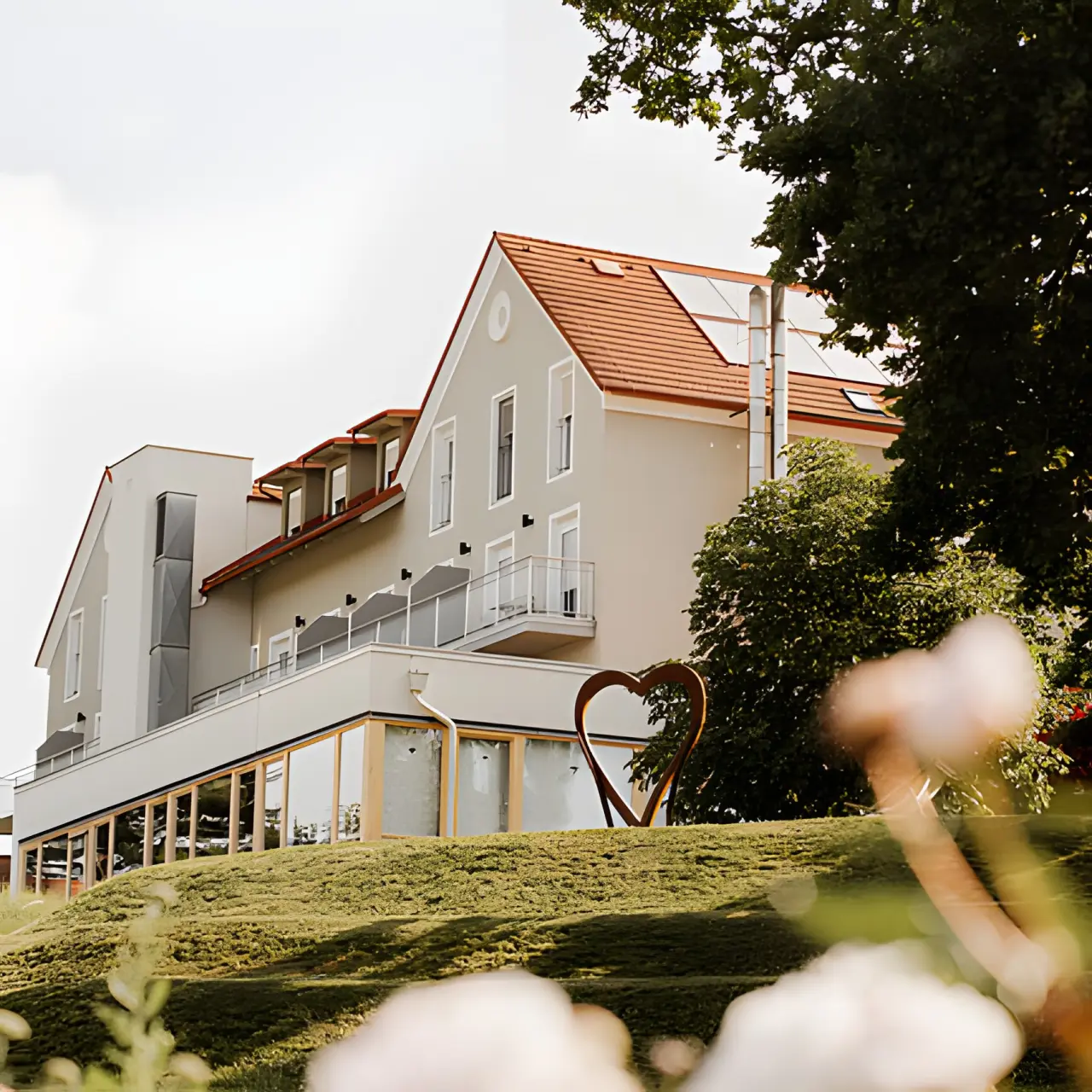 Das Eisenberg in St. Martin an der Raab – Seitenansicht des Hotels mit Herzskulptur | Wellnesshotel Burgenland
