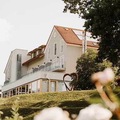 Das Eisenberg in St. Martin an der Raab – Seitenansicht des Hotels mit Herzskulptur | Wellnesshotel Burgenland