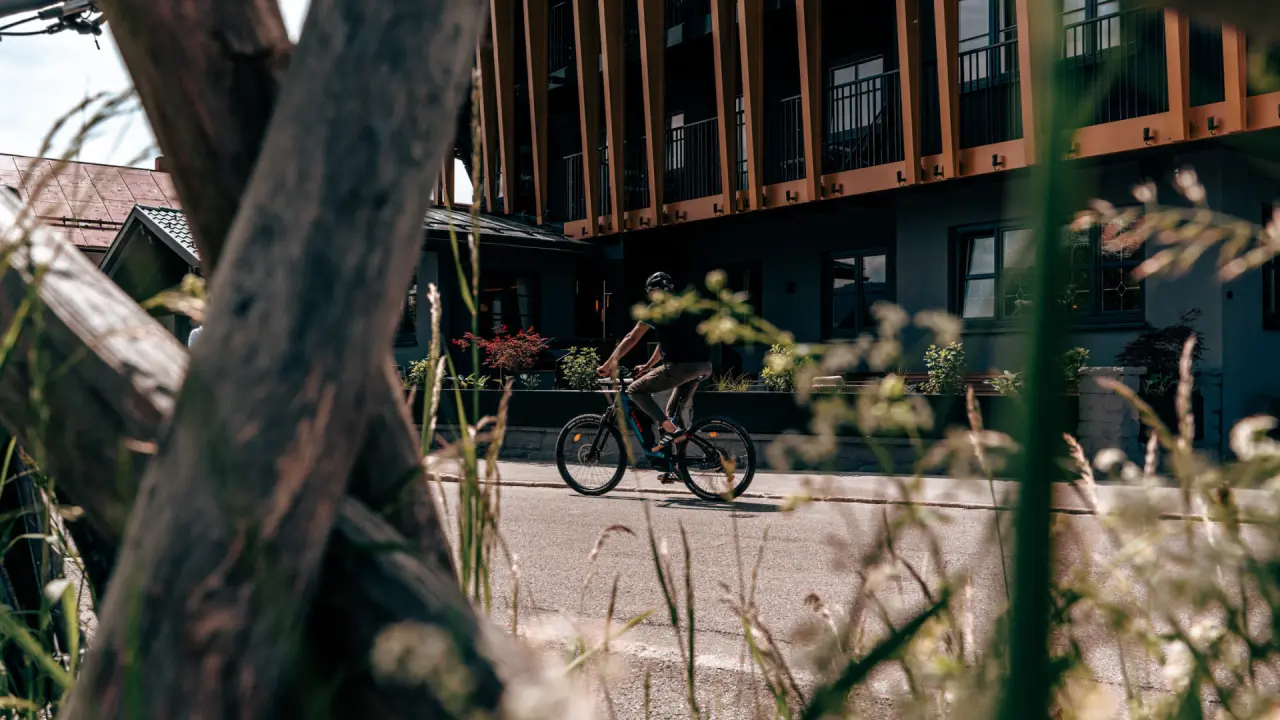 Hotel Alpenkönig in Oberstaufen – Radfahrer vor der modernen Hotelfassade | Wellnesshotel Allgäu