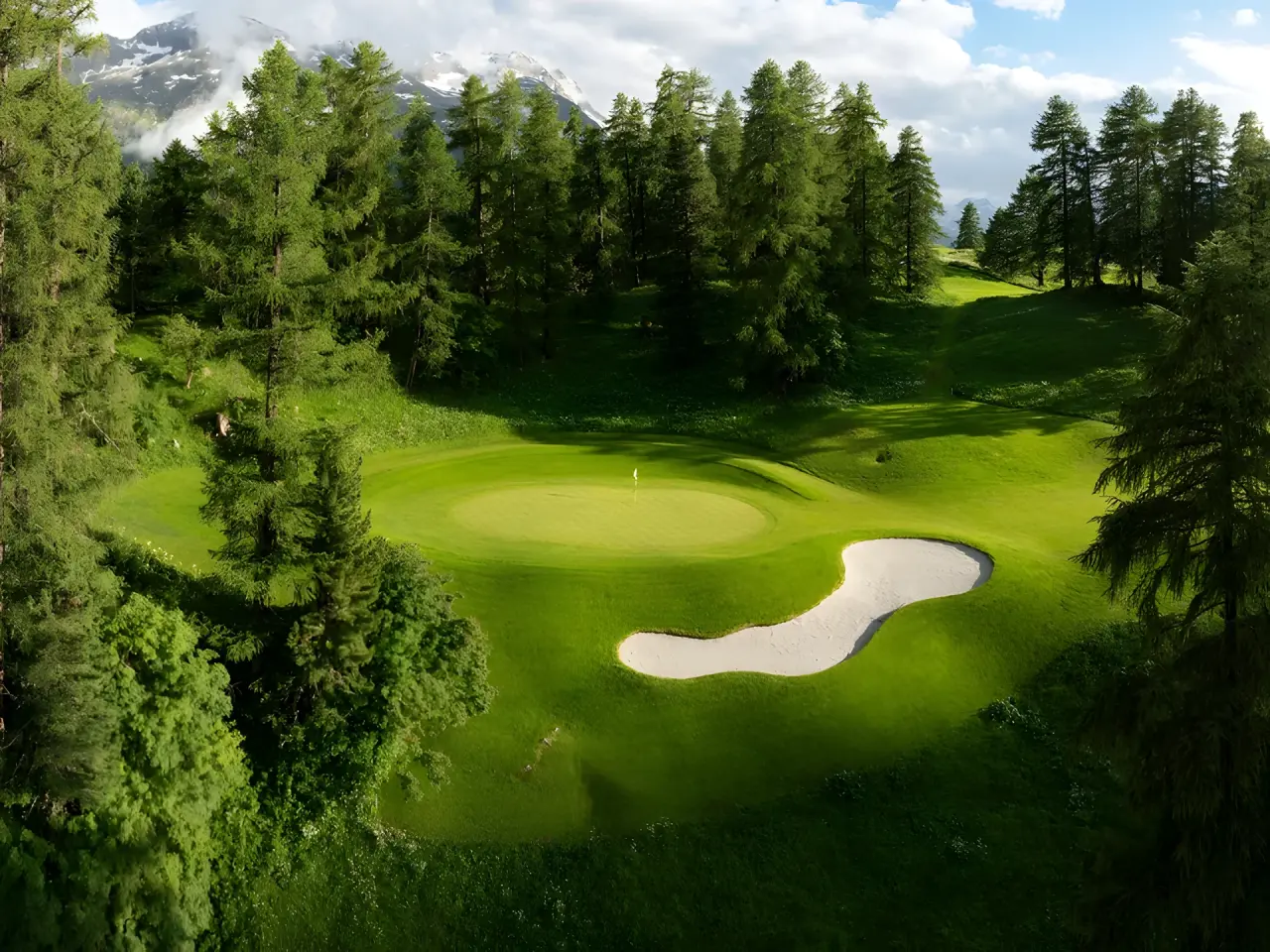 Kulm Hotel St. Moritz in St. Moritz – Grünes Golfplatz-Loch mit Bunker und Bäumen | Wellnesshotel Engadin