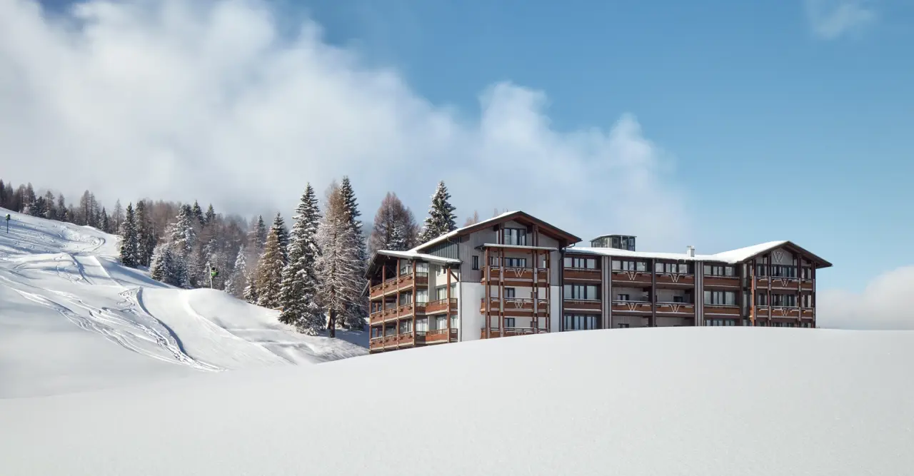 Hotel & Spa Wulfenia in Hermagor – Hotelgebäude im verschneiten Bergpanorama | Wellnesshotel Kärnten