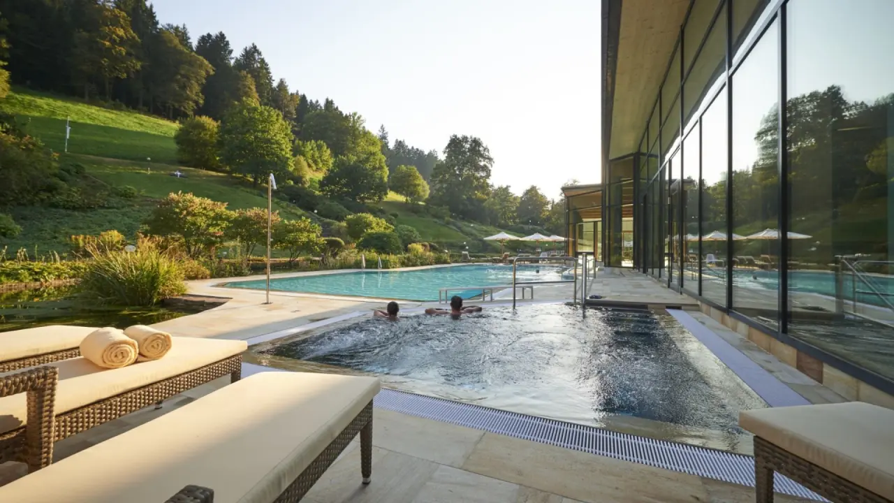 Hotel Therme Bad Teinach in Bad Teinach-Zavelstein – Außenpool mit Gästen und Liegeflächen | Wellnesshotel Schwarzwald