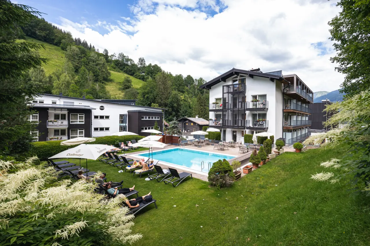 Hotel Der Waldhof in Zell am See – Außenpool mit Liegewiese und entspannenden Gästen | Wellnesshotel Salzburger Land