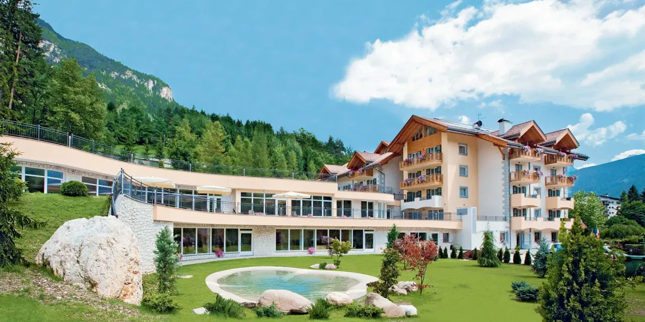 Rio Stava Family Resort & Spa in Tesero – Außenansicht mit Garten und Wasserbecken | Wellnesshotel Trentino