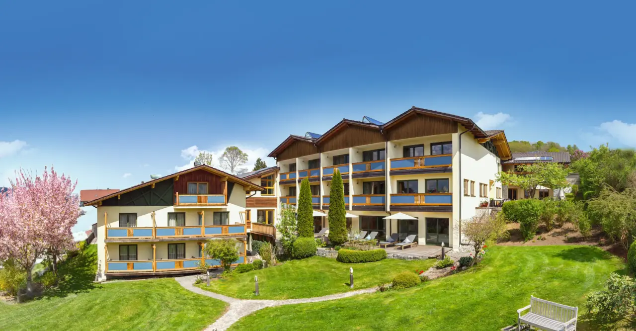 Glashotel Zwiesel in Zwiesel – Hotelgebäude mit weitläufigem Garten und Sitzgelegenheiten | Wellnesshotel Bayerischer Wald