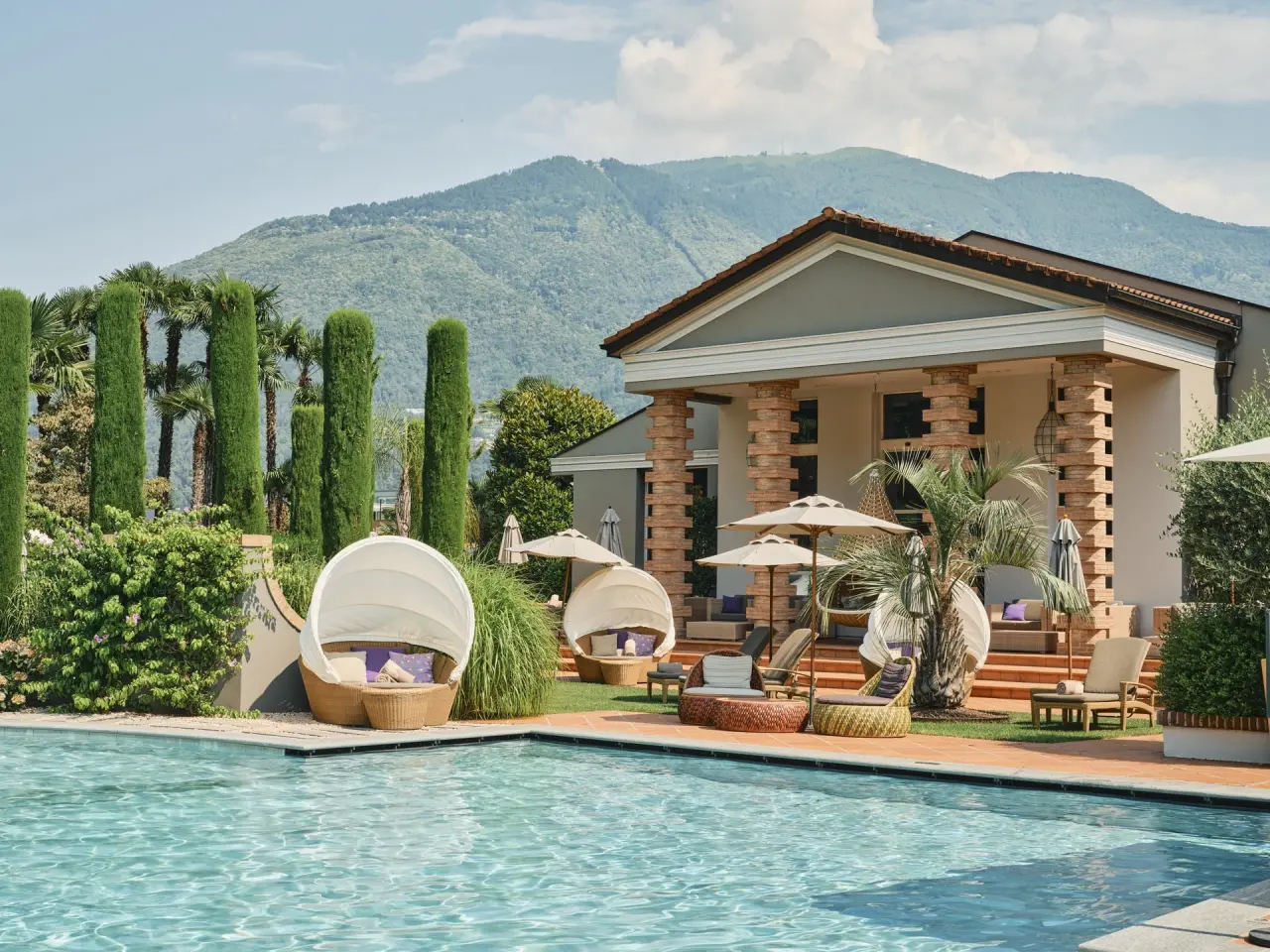 Giardino Ascona in Ascona – Hotelaußenansicht mit Pool und Bergblick | Wellnesshotel Tessin