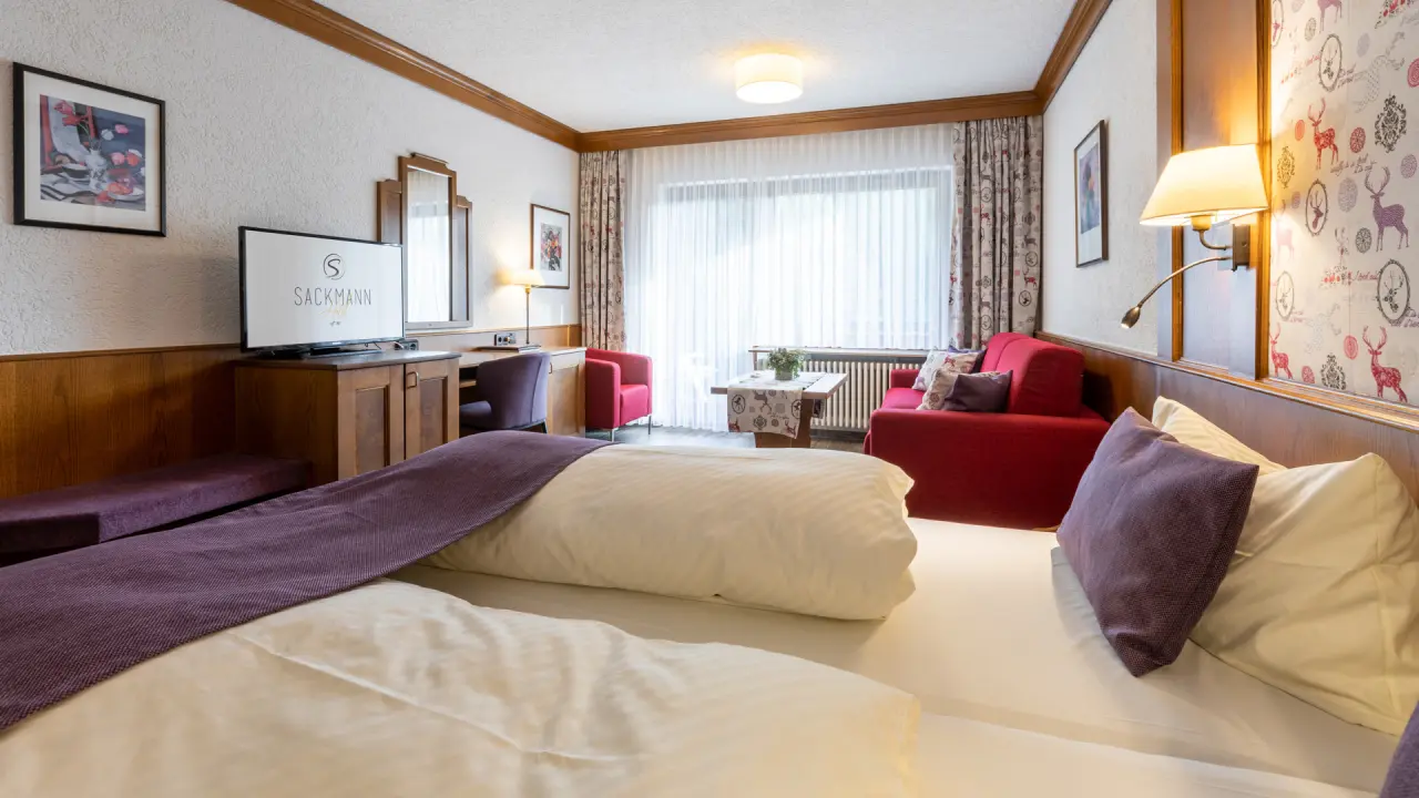 Genusshotel Sackmann in Baiersbronn – Helles und modernes Hotelzimmer mit gemütlicher Sitzecke | Wellnesshotel Schwarzwald