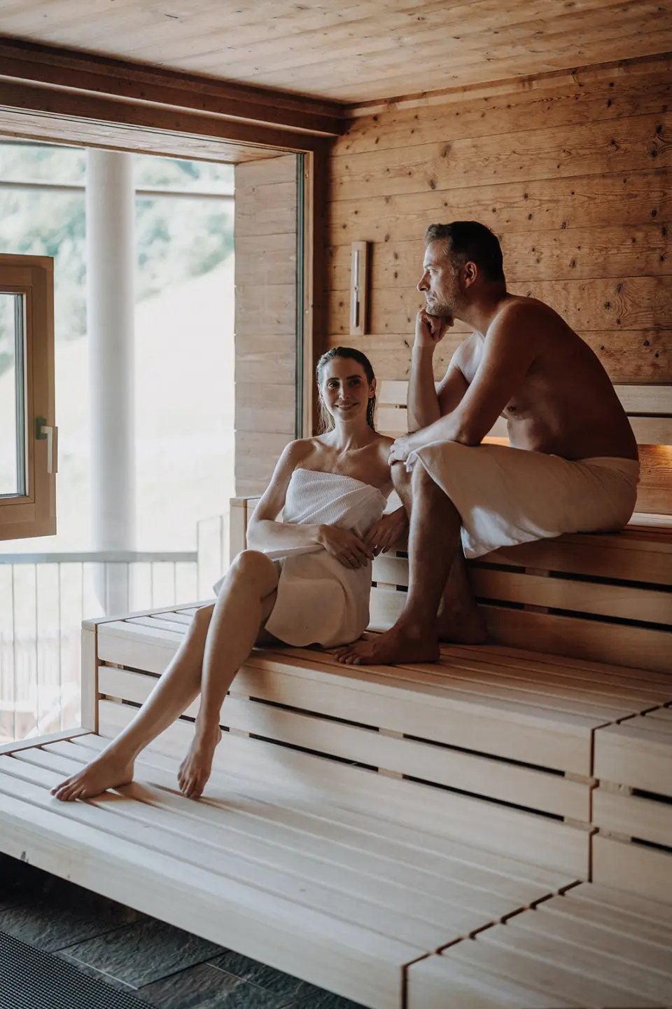 DAS.GOLDBERG in Bad Hofgastein – Entspanntes Paar in der Panorama-Sauna | Wellnesshotel Gasteinertal
