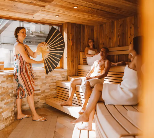 Naturparkhotel Adler St. Roman in Wolfach – Gäste beim entspannenden Aufguss in der Holzsauna | Wellnesshotel Schwarzwald