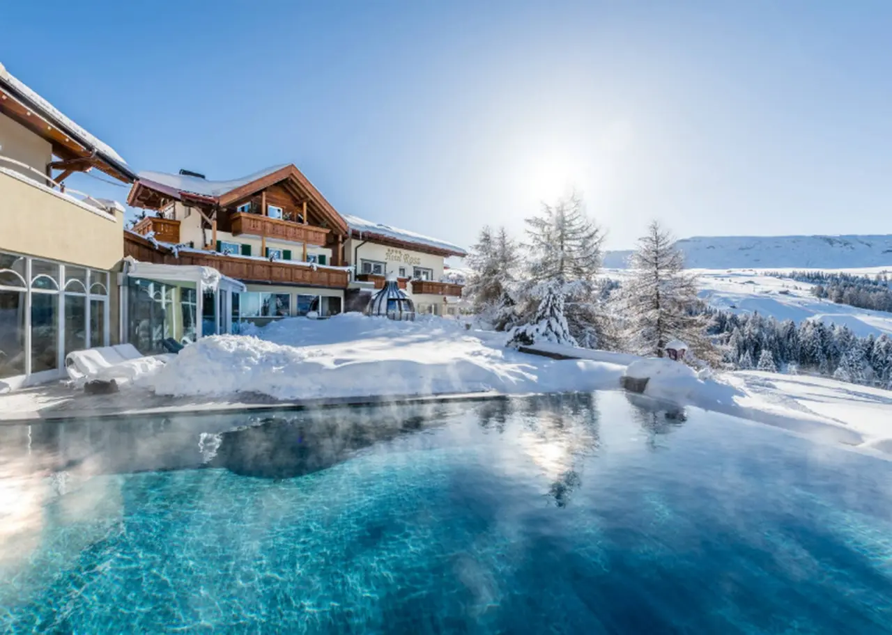 Hotel Rosa ECO Alpine Spa Resort in Kastelruth – Beheizter Außenpool im Winter mit verschneiter Berglandschaft | Wellnesshotel Südtirol