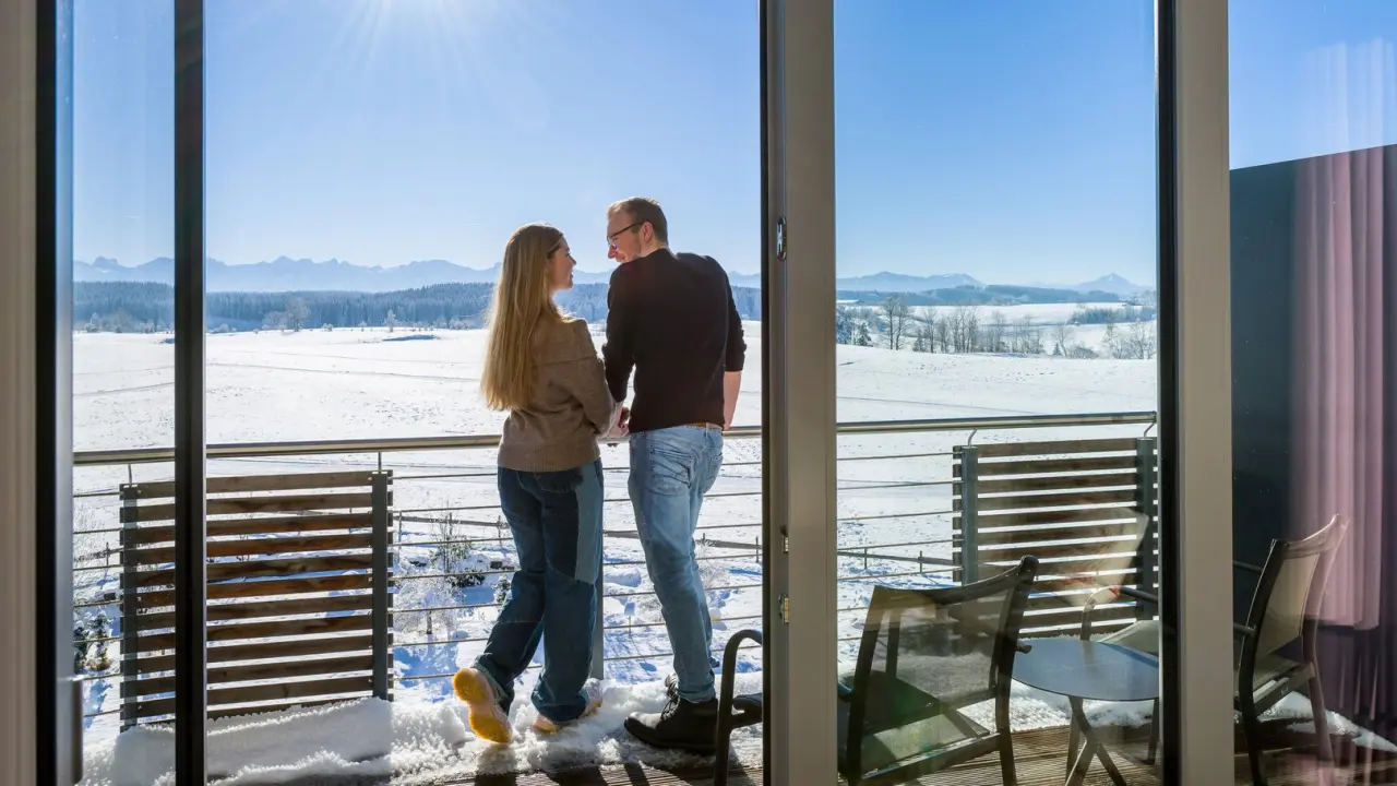 Hotel Das Weitblick Allgäu in Marktoberdorf – Paar auf Balkon mit Winterpanorama | Wellnesshotel Allgäu