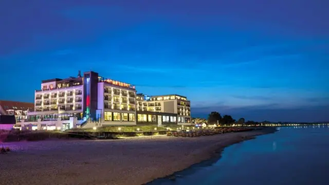Bayside Hotel in Scharbeutz – Hotelgebäude bei Sonnenuntergang direkt am Strand | Wellnesshotel Ostsee