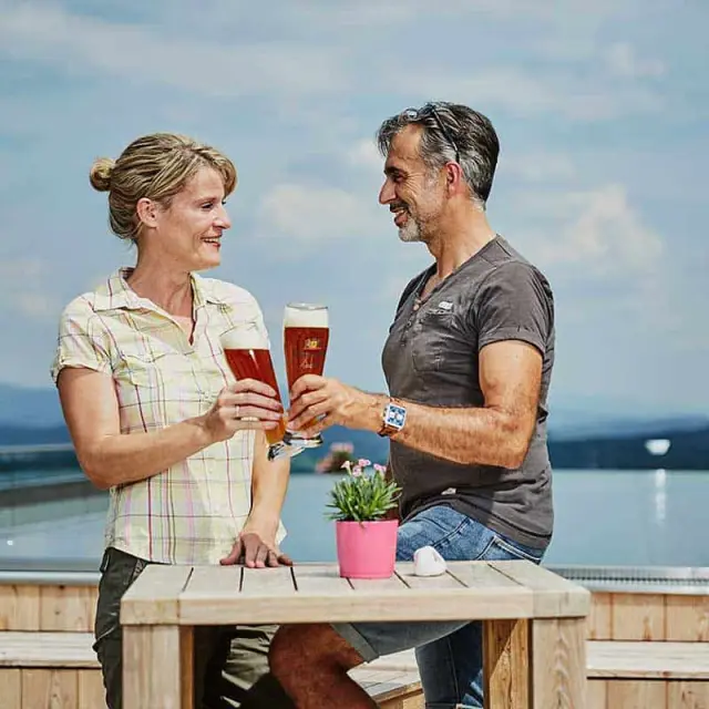 Wellness Hotel Zum Bräu in Kollnburg – Paar stößt mit Bier auf der Terrasse an | Wellnesshotel Bayerischer Wald