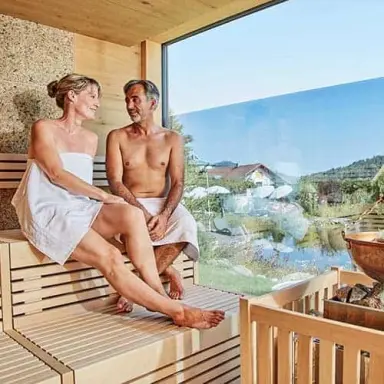 Wellness Hotel Zum Bräu in Kollnburg – Paar entspannt in Panorama-Sauna mit Ausblick | Wellnesshotel Bayerischer Wald