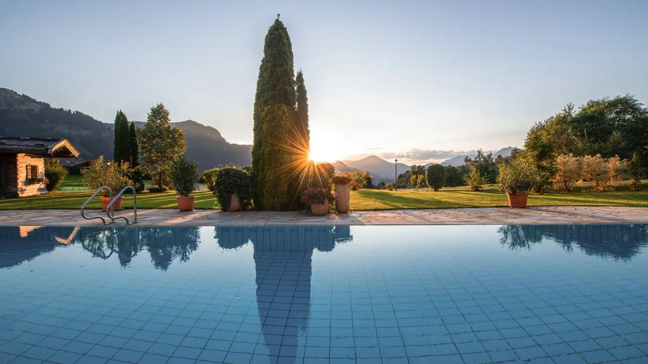 Sport- und Wellnesshotel Bichlhof in Kitzbühel – Außenpool mit Bergblick bei Sonnenuntergang | Wellnesshotel Kitzbüheler Alpen
