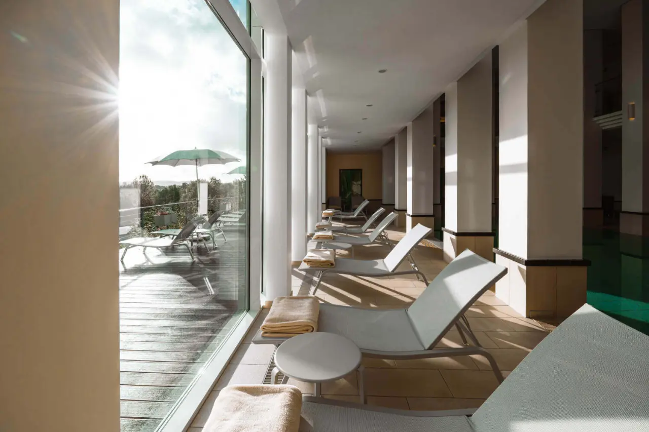 DIEDRICH Wellnesshotel & SPA in Hallenberg – Heller Ruhebereich mit Liegen und Blick ins Grüne | Wellnesshotel Sauerland